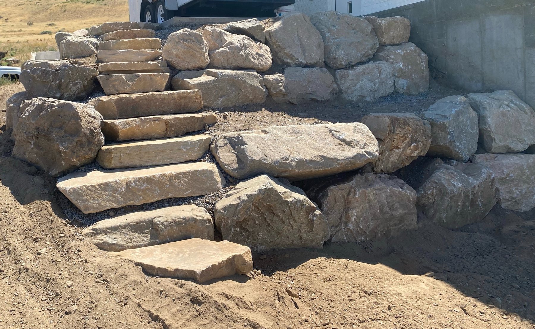 Natural boulder retaining wall with stone staircase